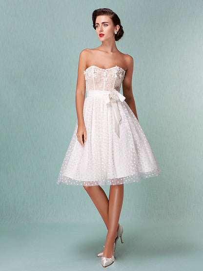 Back view of a strapless sweetheart tulle wedding dress showing the open back and bowknot sash.