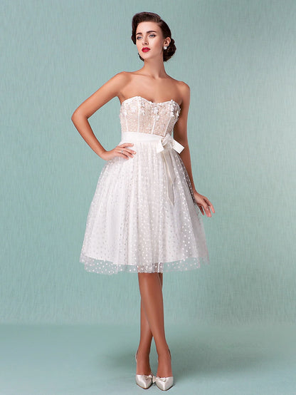 Side view of a princess style knee-length wedding dress with sweetheart neckline and tulle skirt.