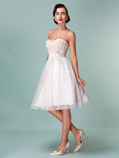 Front view of a strapless tulle wedding dress with sweetheart neckline and bowknot sash.