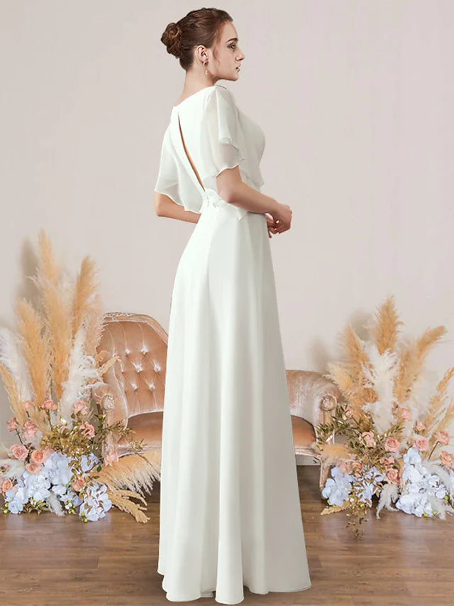Side view of a woman in a white A-line V-neck short sleeve chiffon wedding dress with pleats and appliques.