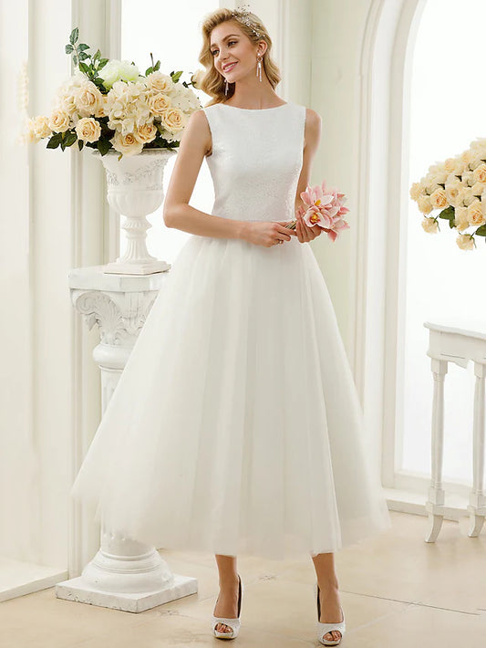 Model wearing a sparkling tea-length A-line wedding dress with a bateau neck and lace details.