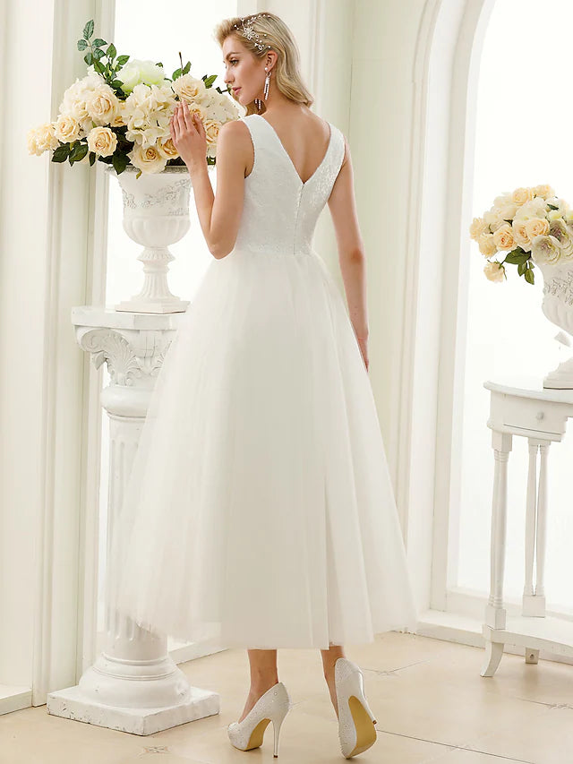 Back view of the wedding dress, highlighting the open back design and delicate lace.
