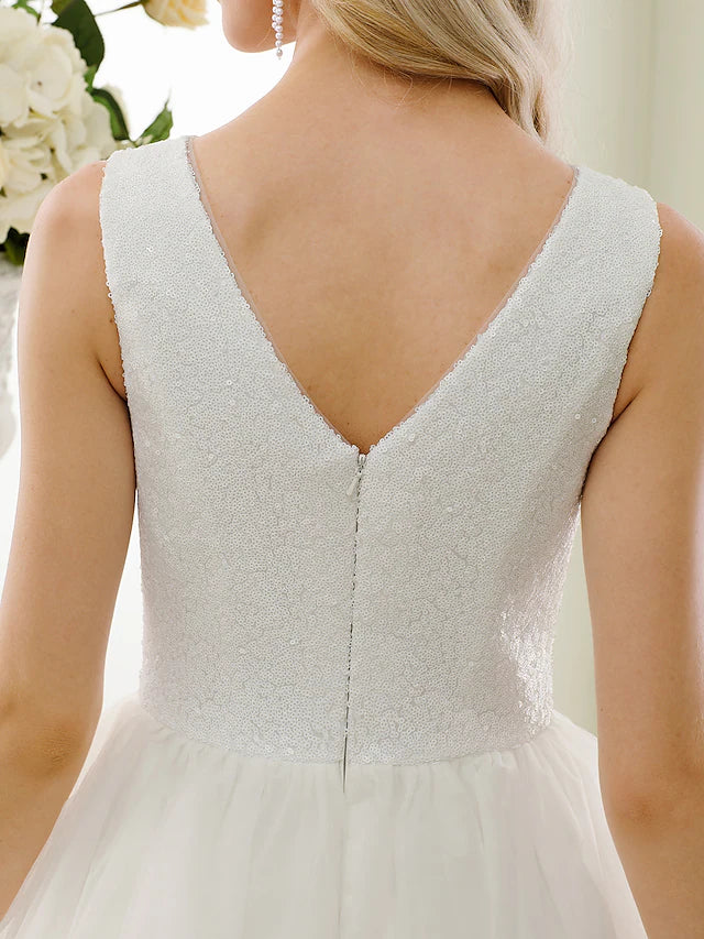 Full view of the sparkling tea-length wedding dress, featuring an open back and sequin details.