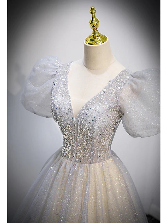 Close-up of the V-neckline and short sleeves of the crystal-embellished dress.