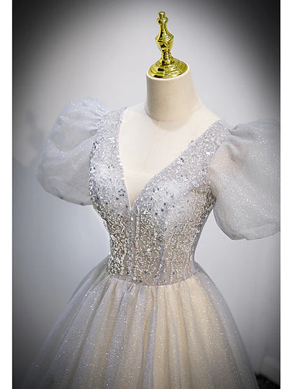 Close-up of the V-neckline and short sleeves of the crystal-embellished dress.